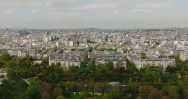 Paris üzerinde uçan bir dronun görüntüsü. Dünyanın en popüler şehrinin şehir manzarası. Ufuk çizgisinde evler ve gökdelenler var. Bir İHA 'dan sinematik çekim. Yüksek kalite 4k