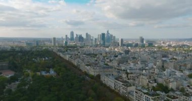 Paris üzerinde uçan bir dronun görüntüsü. Dünyanın en popüler şehrinin şehir manzarası. Ufuk çizgisinde evler ve gökdelenler var. Bir İHA 'dan sinematik çekim. Yüksek kalite 4k