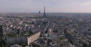 Günbatımında Paris 'in merkezindeki Eyfel Kulesi manzarası. Paris 'in merkez bölgesindeki bir nehrin üzerinden bir insansız hava aracı uçuyor. 5K çözünürlüklü modern bir insansız hava aracından ateşlenmiş. Yüksek kalite 4k görüntü