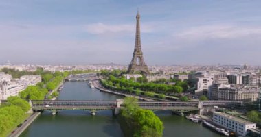 Günbatımında Paris 'in merkezindeki Eyfel Kulesi manzarası. Paris 'in merkez bölgesindeki bir nehrin üzerinden bir insansız hava aracı uçuyor. 5K çözünürlüklü modern bir insansız hava aracından ateşlenmiş. Yüksek kalite 4k görüntü