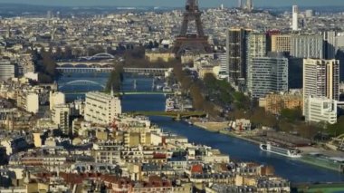 Hava aracı Eiffel Kulesi ve Seine Nehri 'nin uzak günbatımı görüntüsü Paris' teki trafik ve trenleri, Fransa 'daki şehir eğlencelerini birbirine bağlıyor. Telefoto lens ve İHA ile çekilmiş. Yüksek kalite 4k