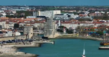 La Rochelle, Fransa 'nın havadan görünüşü. İHA körfezin üzerinde ve yatların üzerinde uçuyor. Tekne Chiene Tur 'u ile Saint-Nicolas Kulesi' nin arasından geçiyor..