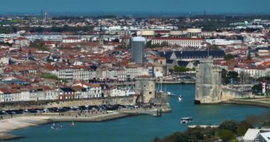 La Rochelle, Fransa 'nın havadan görünüşü. İHA körfezin üzerinde ve yatların üzerinde uçuyor. Tekne Chiene Tur 'u ile Saint-Nicolas Kulesi' nin arasından geçiyor..