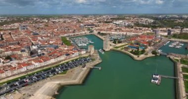 La Rochelle, Fransa 'nın havadan görünüşü. İHA körfezin üzerinde ve yatların üzerinde uçuyor. Tekne Chiene Tur 'u ile Saint-Nicolas Kulesi' nin arasından geçiyor..