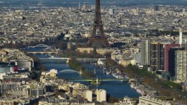 Hava aracı Eiffel Kulesi ve Seine Nehri 'nin uzak günbatımı görüntüsü Paris' teki trafik ve trenleri, Fransa 'daki şehir eğlencelerini birbirine bağlıyor. Telefoto lens ve İHA ile çekilmiş. Yüksek kalite 4k