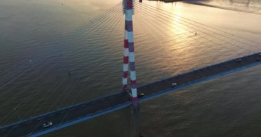 Kablo destekli Fransız köprüsünün üzerinde uçuyor. İnanılmaz bir gün doğumu. Saint Nazaire Köprüsü 'nün havadan görünüşü Fransa' nın Loire nehri boyunca uzanan bir köprü olarak kaldı..