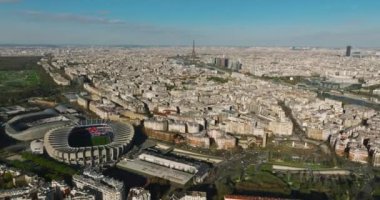 Paris, Fransa 'daki modern bir spor stadyumunun kuş bakışı görüntüsü. Bir İHA bir spor tesisinin üzerinde uçuyor. Şehir merkezinin ve çatıların havadan görüntüsü. Yüksek kalite 4k görüntü
