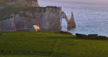 Bir İHA Fransa 'nın Etretat kentindeki tebeşir uçurumlarıyla kıyı şeridinde uçuyor. Atlantik Okyanusu 'nun kıyısındaki resim gibi bir yerin havadan görünüşü. Kayalar, uçurumlar, tepeler bir İHA 'dan kaydedilmiş..