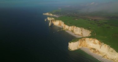 Gün batımında Fransa 'da Atlantik Okyanusu' nun güzel kayalık kıyılarını çekiyoruz. Fransa 'nın en çok ziyaret edilen etkinliklerinden biri olan Etretat' ın modern insansız hava aracı görüntüsü. Okyanustaki yeşil golf sahaları.