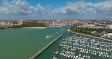 La Rochelle, Fransa 'nın havadan görünüşü. İHA körfezin üzerinde ve yatların üzerinde uçuyor. Tekne Chiene Tur 'u ile Saint-Nicolas Kulesi' nin arasından geçiyor..
