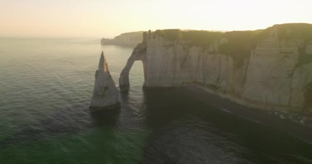 日没時にフランスで大西洋の美しい岩の海岸を撮影確立します フランス エトルトで最も訪問された観光スポットの一つの近代的な無人機からの眺め 海の緑のゴルフコース — ストック動画