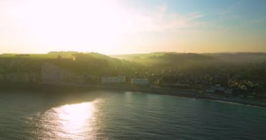 Atlantik kıyısındaki Fransız sınır işaretinin insansız hava aracı görüntüsü. Fransa kıyıları Atlantik Okyanusu ile çevrilidir. Fransa 'da yeşil çayırları olan yüksek uçurumlar. Deniz kıyısında yürüyen insanlar.