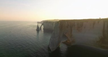 Atlantik kıyısındaki Fransız sınır işaretinin insansız hava aracı görüntüsü. Fransa kıyıları Atlantik Okyanusu ile çevrilidir. Fransa 'da yeşil çayırları olan yüksek uçurumlar. Deniz kıyısında yürüyen insanlar.