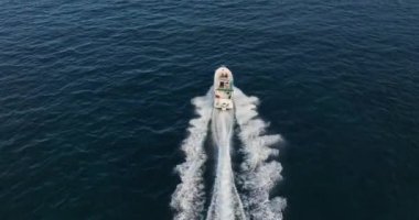 Güneşli bir günde mavi Akdeniz 'de yüzen teknenin havadan görüntüsü. Drone 'dan deniz burnu. Deniz yüzeyindeki en hızlı tekne..