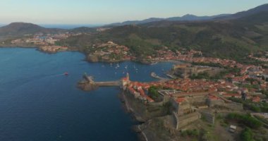 Fransa 'nın güneyinde, Perpignan yakınlarında, Aerial view Collioure kasabasında. Port dAvall plajı ve kraliyet kalesi solda ve deniz feneri sağda. Denizin üzerindeki drone hava görüntüsü.