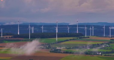 Güçlü rüzgar türbini çiftliğinin hava manzarası. Güzel bulutlu gökyüzünde, sisli bir havada enerji üretimi..