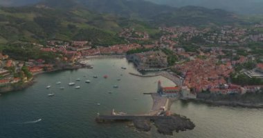 Perpignan yakınlarındaki Collioure kasabasında. Port dAvall plajı ve kraliyet kalesi solda ve deniz feneri sağda. Denizin üzerindeki drone hava görüntüsü.