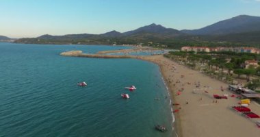Fransa 'nın güneyindeki kumsalda Perpignan ve Lucate şehirlerinin yakınında. Turistler sıcak Akdeniz kıyılarında da dinleniyorlar. Deniz kıyısında gün batımı. Güney Fransa 'da tatiller.
