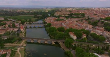 Yazın güneşli bir günde Fransa 'nın eski Beziers kasabası havadan izleniyor. Nehrin üzerindeki eski köprülerin güzel manzarası.