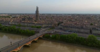 Fransa 'nın Bordeaux şehrinin çekimleri. Bir dron eski bir Avrupa şehrinin üzerinde uçuyor. Batı Fransa 'da günbatımı. Bisikletle Pont de Pierre köprüsünden geçen tramvaylar ve turistler.