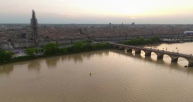 Fransa 'nın Bordeaux şehrinin çekimleri. Bir dron eski bir Avrupa şehrinin üzerinde uçuyor. Batı Fransa 'da günbatımı. Bisikletle Pont de Pierre köprüsünden geçen tramvaylar ve turistler.