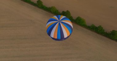 Yeşil manzaranın üzerinde uçan sıcak hava balonu manzarası, ABD. Drone atış balonu. Macera kavramı, eğlence, uçmak. Günbatımı sıcak hava balonu gezisi sahnesini kapatın. Sıcak renkli balon sepeti günbatımı.