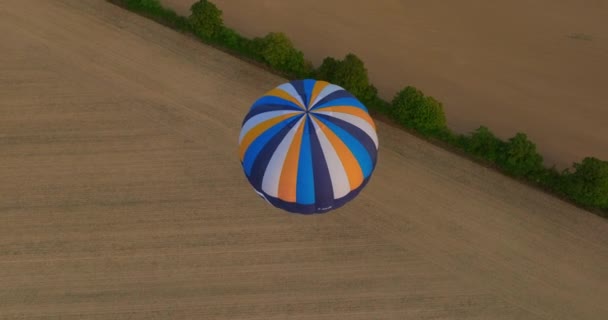 热气球在绿地之上飞行的顶部视图 无人机发射气球 冒险的概念 关闭日落热气球骑现场 色彩艳丽的热气球篮夕阳 — 图库视频影像