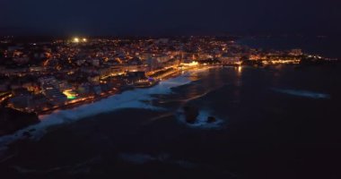 Geceleri Biarritz şehrinin inanılmaz güzel hava manzarası. Gece ışıklarıyla aydınlatılan okyanus dalgaları gece turistlerinin sahillerini yıkıyor. Fransa.