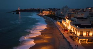 Geceleri Biarritz şehrinin inanılmaz güzel hava manzarası. Gece ışıklarıyla aydınlatılan okyanus dalgaları gece turistlerinin sahillerini yıkıyor. Fransa.