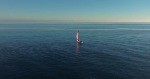 空からの眺め ヨットは風の強い日の空気で開かれた海で航海します オーシャンベイで白い帆船の上に輝く太陽 — ストック動画