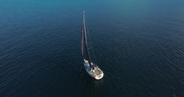 深い青い海と熱帯のエキゾチックな湾で航海する美しい帆船 太陽の光線でヨットの航空ショットを確立する ドローンから撮影された海の帆船ヨットのシルエット — ストック動画