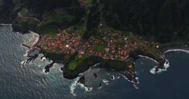 Yıllar önce sızan volkanik kayanın üzerindeki Seixal kasabasının insansız hava aracı görüntüsü inanılmazdı. Portekiz 'in Madeira şehrinde küçük bir belediye.