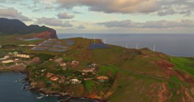 Şafak vakti okyanusun üzerindeki bir tepenin üzerinde duran yel değirmenlerinin havadan görünüşü Canical, Madeira, Portekiz.