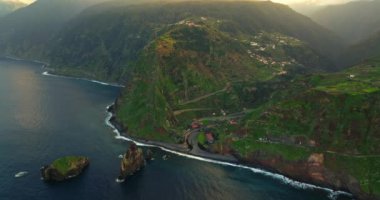 Gün batımında deniz manzaralı büyük bir kaya, Miradouro da Ribeira da Janela. Madeira Adası, Portekiz, Atlantik Okyanusu.