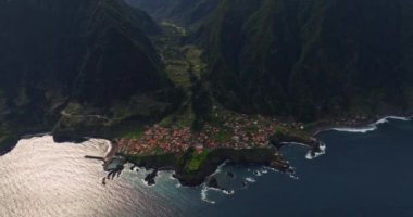 Yıllar önce sızan volkanik kayanın üzerindeki Seixal kasabasının insansız hava aracı görüntüsü inanılmazdı. Portekiz 'in Madeira şehrinde küçük bir belediye.