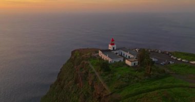 Deniz fenerinin Madeira Ponto da Pargo 'nun batı kıyısındaki insansız hava aracından okyanusun üzerindeki bir uçuruma tünemiş inanılmaz bir görüntüsü..
