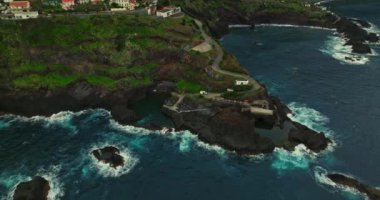 Portekiz, Madeira Adaları, Seixal 'ın hava manzarası. Dik bir okyanus kıyısındaki tatil köyü. Köy, okyanusa giren volkanik bir oluşum üzerine kurulmuş ve okyanus dalgalarıyla yıkanmış..