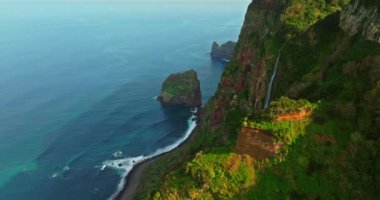 Atlantik Okyanusu 'ndaki yeşil bir adanın kıyısında. Dağlarla ve okyanus kayalıklarıyla Madeira manzarası. Madeira Adası 'nın engebeli kıyı şeridinin nefes kesici manzarası.