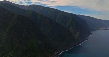 Atlantik Okyanusu 'ndaki yeşil bir adanın kıyısında. Dağlarla ve okyanus kayalıklarıyla Madeira manzarası. Madeira Adası 'nın engebeli kıyı şeridinin nefes kesici manzarası.