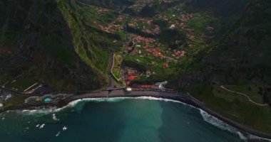 Atlantik Okyanusu 'ndaki yeşil bir adanın kıyısında. Dağlarla ve okyanus kayalıklarıyla Madeira manzarası. Madeira Adası 'nın engebeli kıyı şeridinin nefes kesici manzarası.