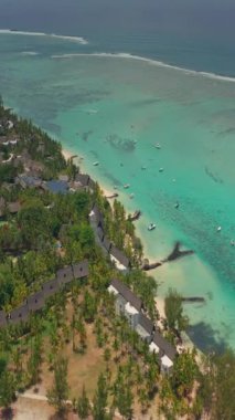 Palmiye ağaçları ve güzel sahil gölünün üzerinden uç. Mauritius 'taki Cennet Adası. Sahil şeridi boyunca manzara manzarası. Mauritius sahilinin havadan görünüşü cennet adasında güneşli bir gün..