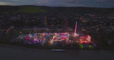 Fransa 'daki eğlence parkının havadan görünüşü. Alacakaranlık Aydınlatma Joigny Şehri temalı ünlü lunapark Yonne Riverside şehir merkezi panoraması. Manzaralı lunaparkın günbatımı görüntüsü.