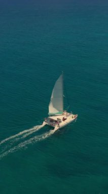 Lüks katamaranların açık mavi okyanusta seyahat ederken çekilmiş hava aracı izleme videosu..