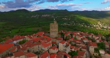 Fransa 'da Montpeyroux köyünün etrafındaki hava manzarası güneşli bir baharda, merkezde bir kuleyle birlikte..