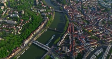 Mavi bir nehir boyunca, gün batımında şehrin üzerinde, tepeden aşağı insansız hava aracı vuruldu. Bir turist gemisi nehir boyunca ilerliyor. Lyon, Fransa.