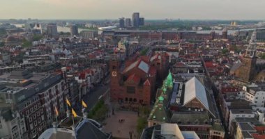 İnsansız hava aracı Amsterdam yaz şehirlerini, dar evleri, kanalları vurdu. Amsterdam, Hollanda 'nın ünlü yerlerinin hava manzarası. Göz kamaştırıcı, keskin çatıların ve modern binaların ön cephelerinin en üst görüntüsü..
