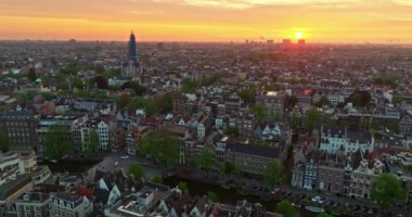 İnsansız hava aracı Amsterdam yaz şehirlerini, dar evleri, kanalları vurdu. Amsterdam, Hollanda 'nın ünlü yerlerinin hava manzarası. Göz kamaştırıcı, keskin çatıların ve modern binaların ön cephelerinin en üst görüntüsü..