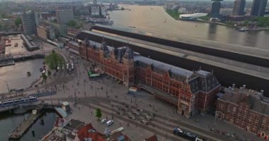 İnsansız hava aracı Amsterdam yaz şehirlerini, dar evleri, kanalları vurdu. Amsterdam, Hollanda 'nın ünlü yerlerinin hava manzarası. Göz kamaştırıcı, keskin çatıların ve modern binaların ön cephelerinin en üst görüntüsü..