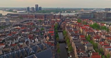 İnsansız hava aracı Amsterdam yaz şehirlerini, dar evleri, kanalları vurdu. Amsterdam, Hollanda 'nın ünlü yerlerinin hava manzarası. Göz kamaştırıcı, keskin çatıların ve modern binaların ön cephelerinin en üst görüntüsü..