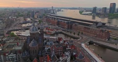 İnsansız hava aracı Amsterdam yaz şehirlerini, dar evleri, kanalları vurdu. Amsterdam, Hollanda 'nın ünlü yerlerinin hava manzarası. Göz kamaştırıcı, keskin çatıların ve modern binaların ön cephelerinin en üst görüntüsü..